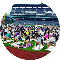 Oms in the Outfield participants practice their best downward dog